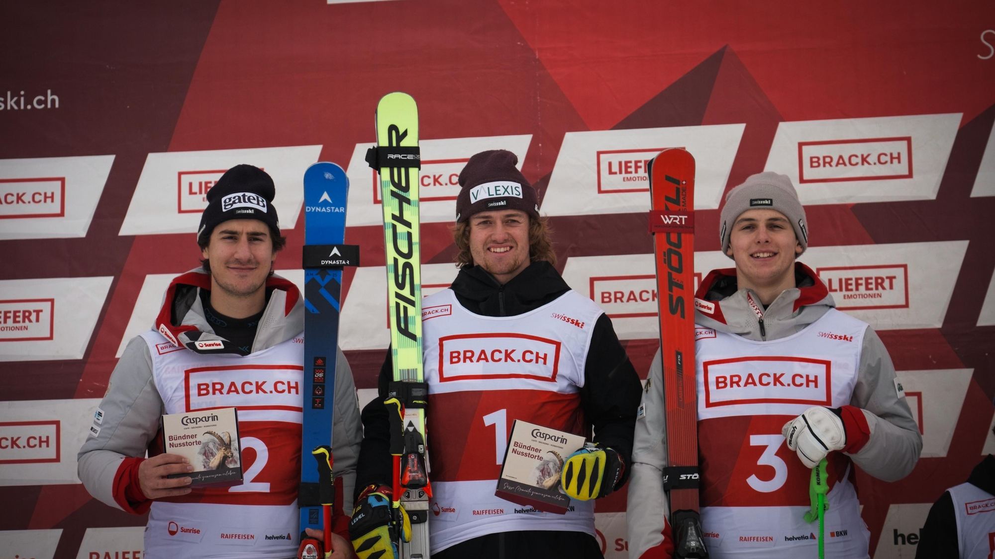 Oliver Florin als Sieger in der Mitte des Podests, mit seinen Fischer-Ski